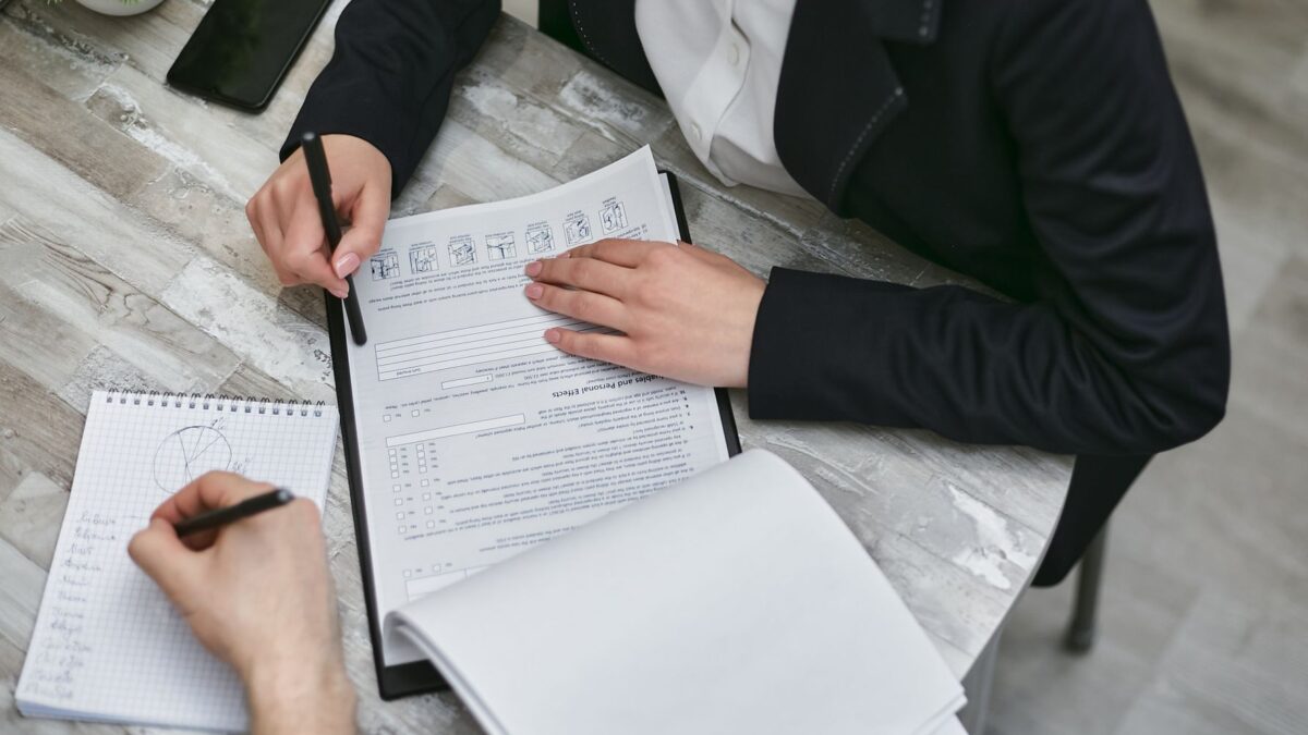 Documentos de visto de trabalho sendo revisados em reunião de negócios