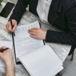 Documentos de visto de trabalho sendo revisados em reunião de negócios