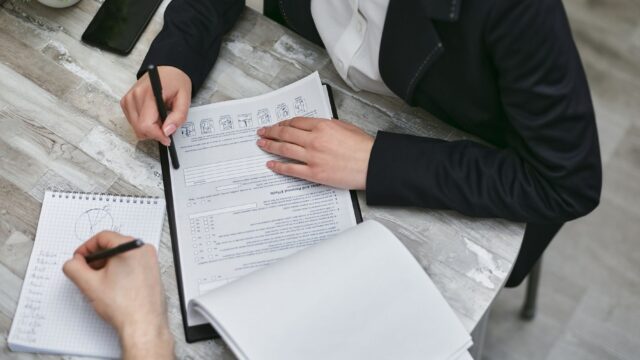 Documentos de visto de trabalho sendo revisados em reunião de negócios