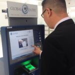 Viajante usando quiosque do Global Entry no aeroporto internacional de Miami