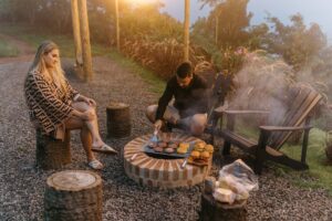 Amigos reunidos em torno de uma churrasqueira em um quintal ao entardecer