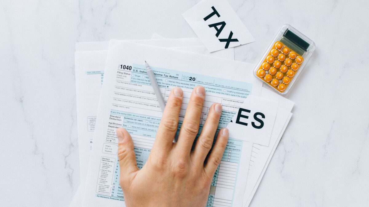 Formulário de imposto 1040 e calculadora sobre mesa, representando o prazo de 15 de outubro do IRS