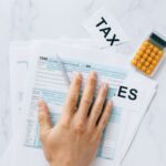 Formulário de imposto 1040 e calculadora sobre mesa, representando o prazo de 15 de outubro do IRS