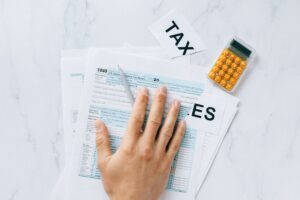 Formulário de imposto 1040 e calculadora sobre mesa, representando o prazo de 15 de outubro do IRS