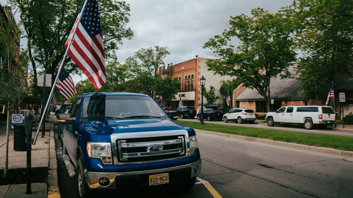 Rua principal de uma pequena cidade americana com bandeiras dos EUA, representando o centro de Danbury, Connecticut