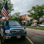 Rua principal de uma pequena cidade americana com bandeiras dos EUA, representando o centro de Danbury, Connecticut
