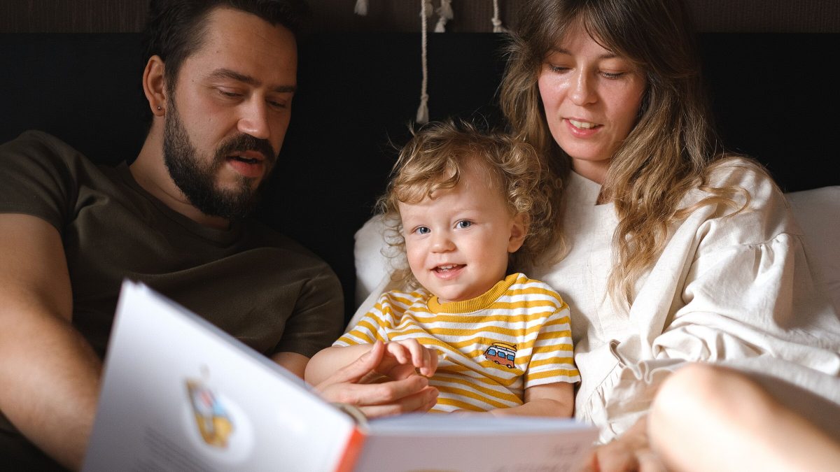 Mãe e filho lendo um livro juntos, sentados no tapete da sala