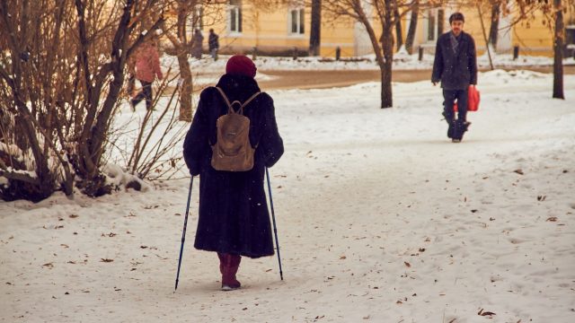 Pessoas caminhando agasalhadas em um parque coberto de neve durante o inverno nos Estados Unidos