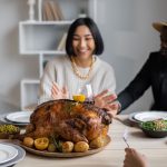 Família reunida à mesa de Thanksgiving com peru assado, celebrando o feriado americano