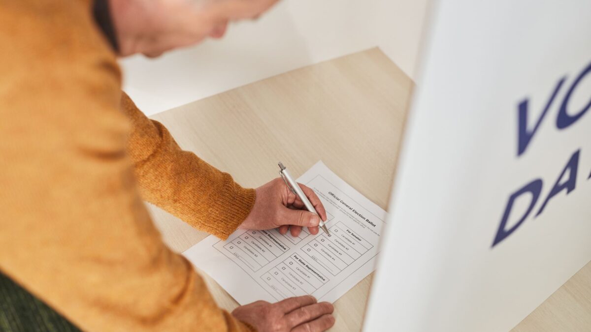 Homem votando em cabine eleitoral, representando o dia da votação do 1º turno das Eleições 2026