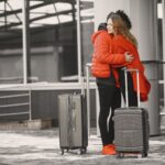 Mulher abraça o filho com malas de viagem, cena de reencontro em aeroporto